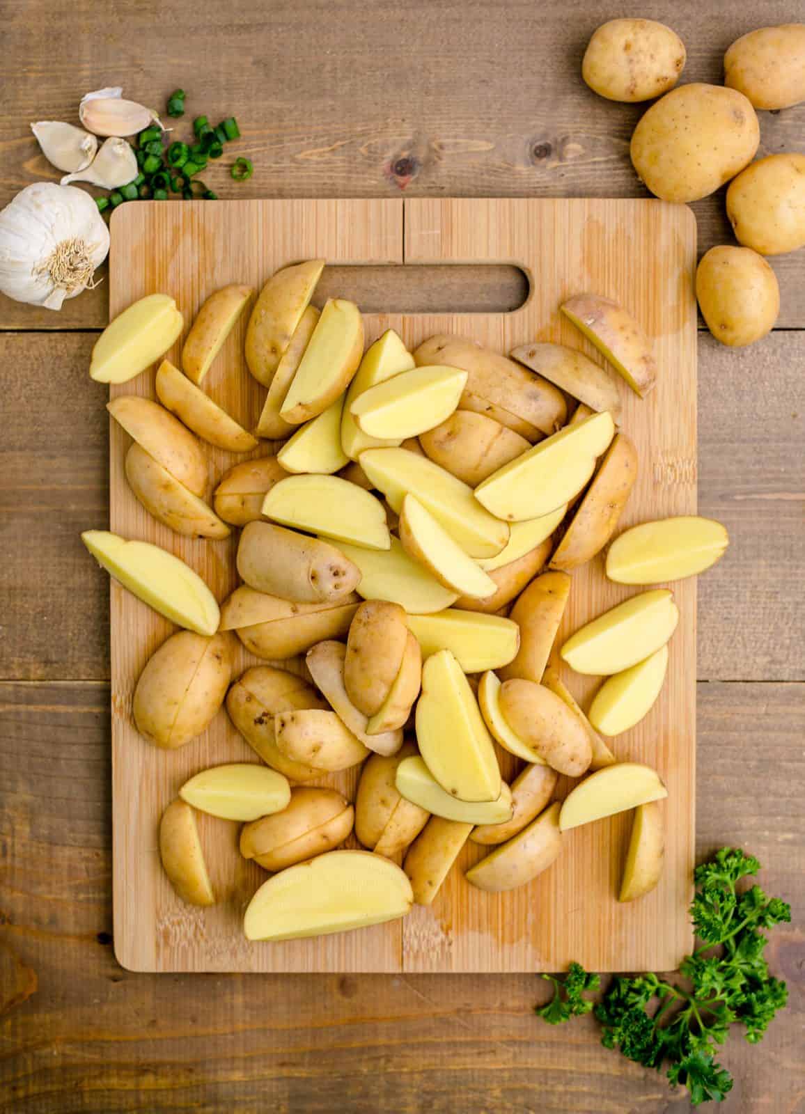 Potatoes cut on cutting board.