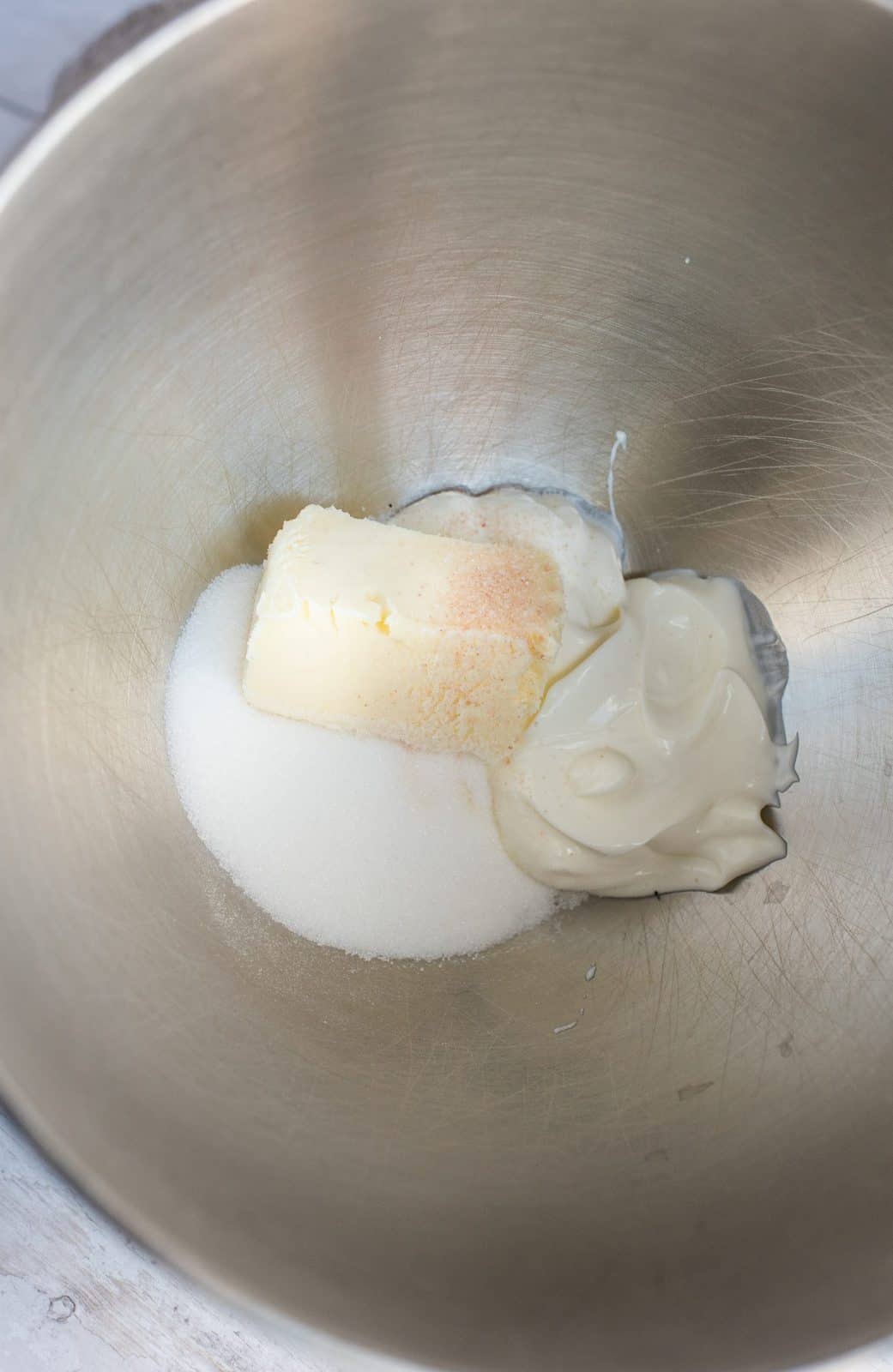 Sugar, butter and sour cream in bowl of stand mixer.