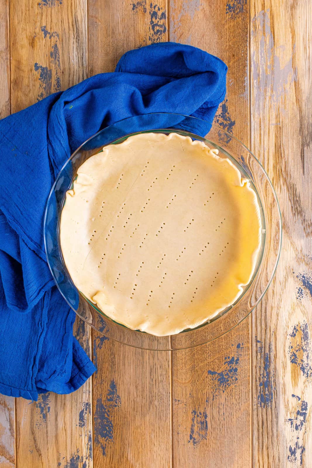 pie crust that has been poked with a fork inside a pie pan.