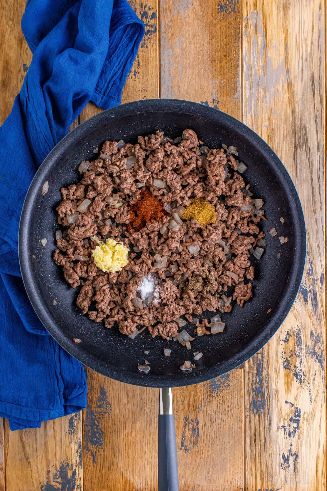 taco seasonings and garlic added to cooked ground beef in skillet.