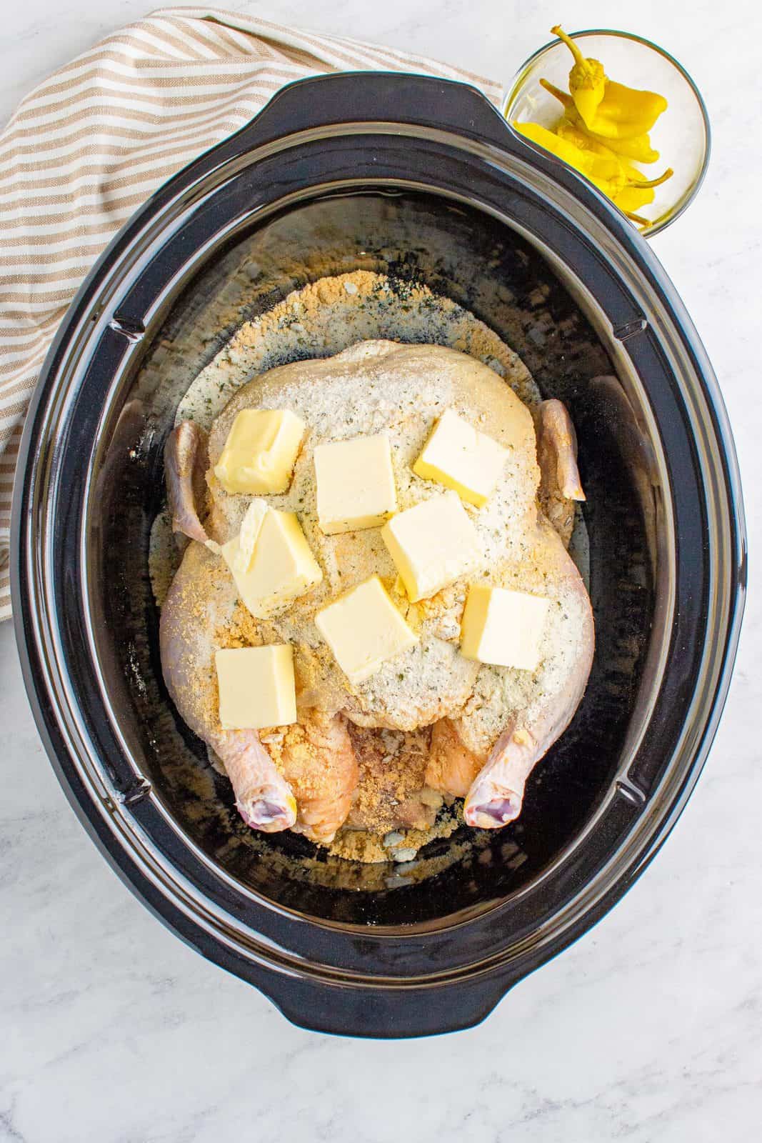 Pats of butter on top of chicken in crock pot.