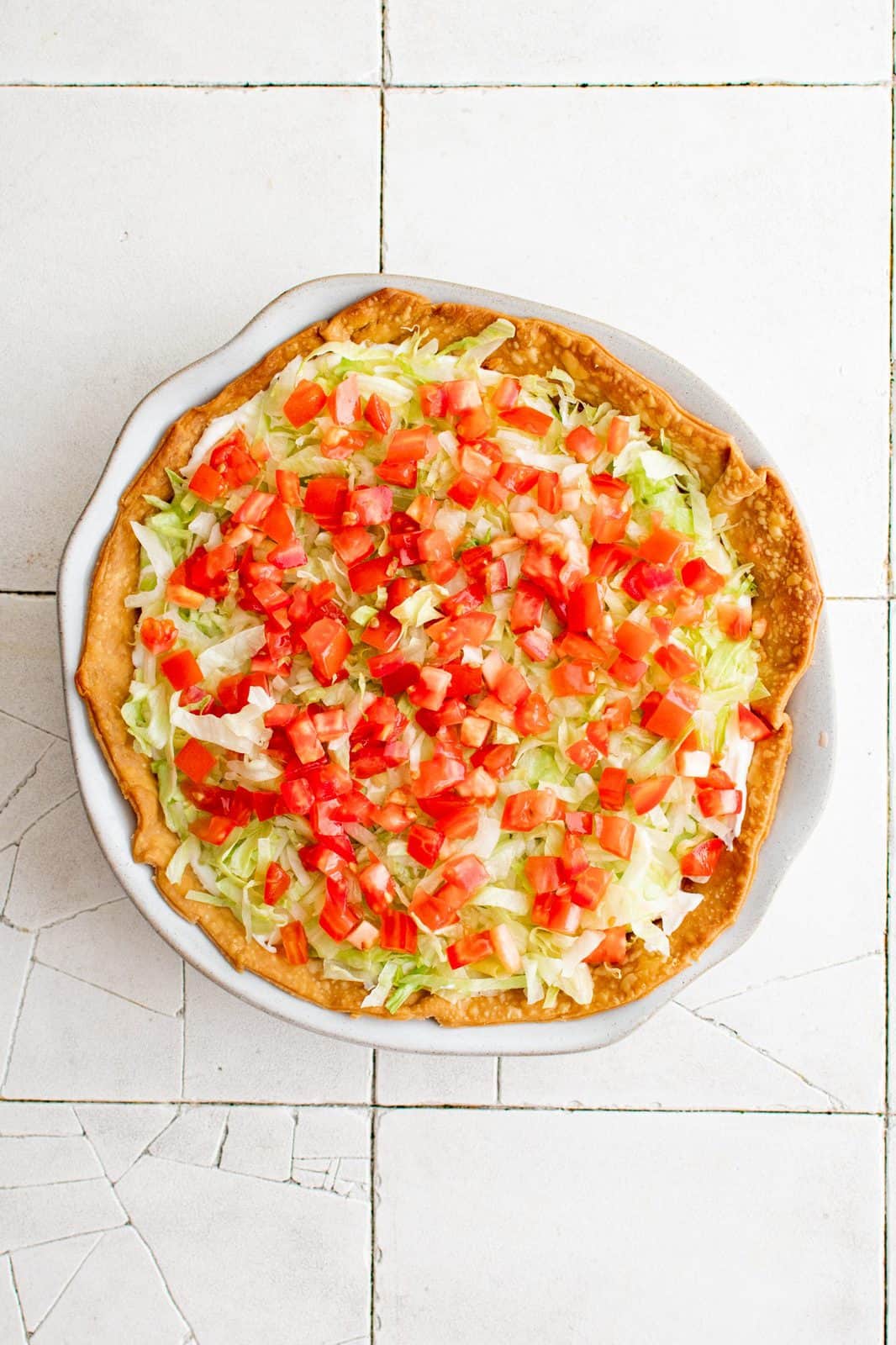 Sour cream, lettuce, tomatoes and olives added to top of baked pie.