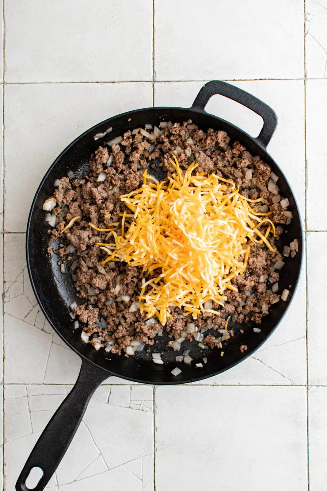 Shredded cheese added to ground beef mixture.