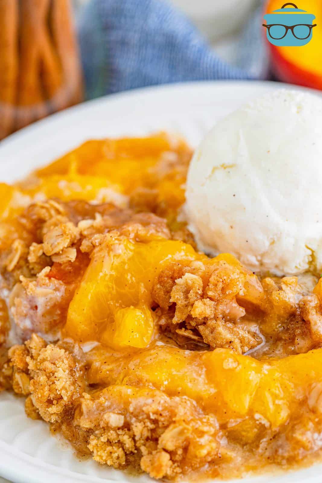 Easy Fresh Peach Crisp on plate topped with ice cream.
