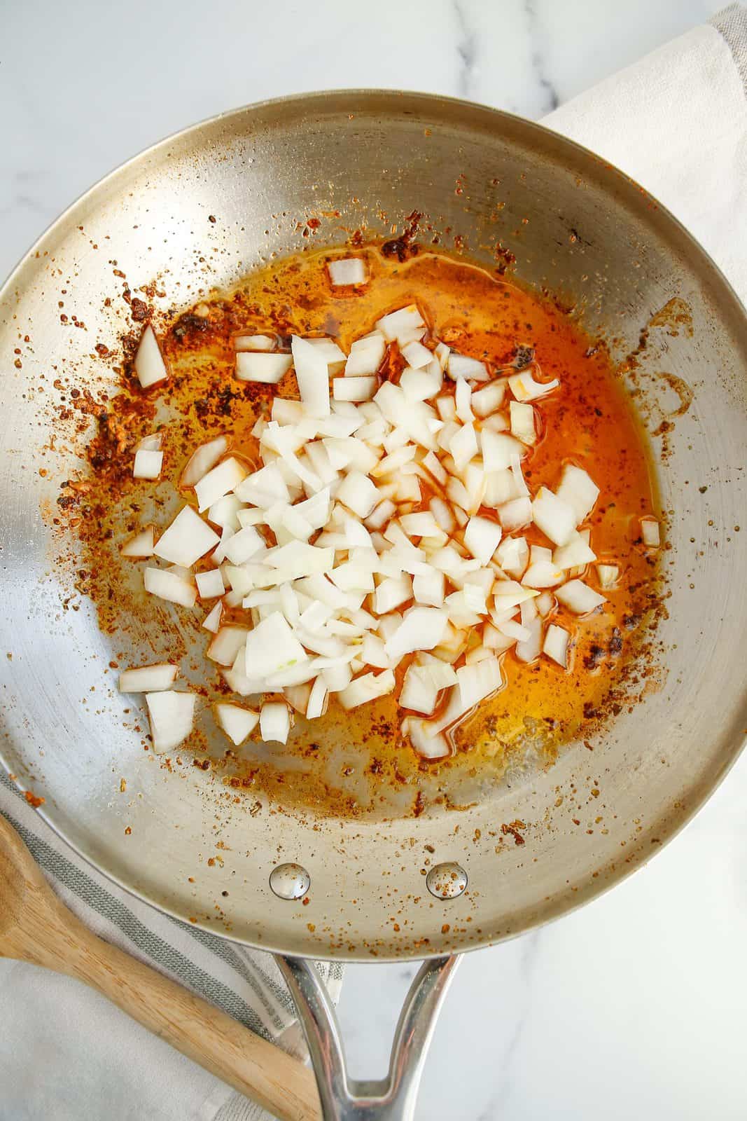 Onions being sauteed in skillet.