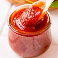 Square image of spoon in jar with Ketchup
