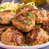 Square image of plated meatballs with parsley