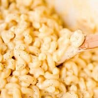 Square image of Stove Top Macaroni and Cheese with wooden spoon lifting up pasts.
