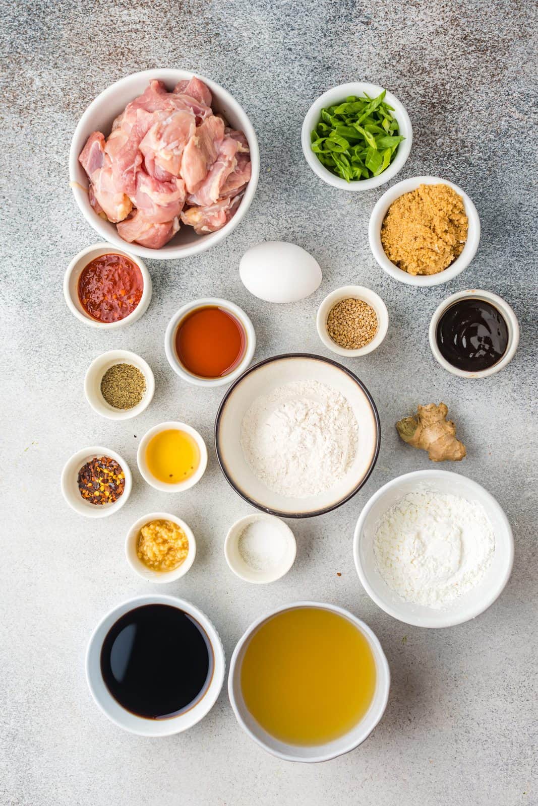 Ingredients needed: chicken thighs, cornstarch, all-purpose four, egg, salt, pepper, chicken broth, cornstarch, brown sugar, hoisin sauce, soy sauce, garlic, ginger, rice vinegar, toasted sesame oil, chili flakes, chili sauce, green onion and sesame seeds.