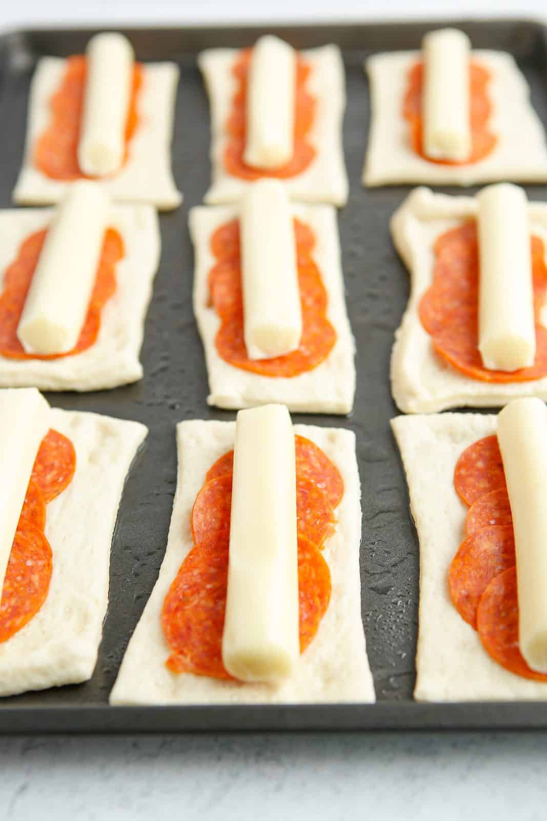 String cheese placed on top of pepperoni slices.