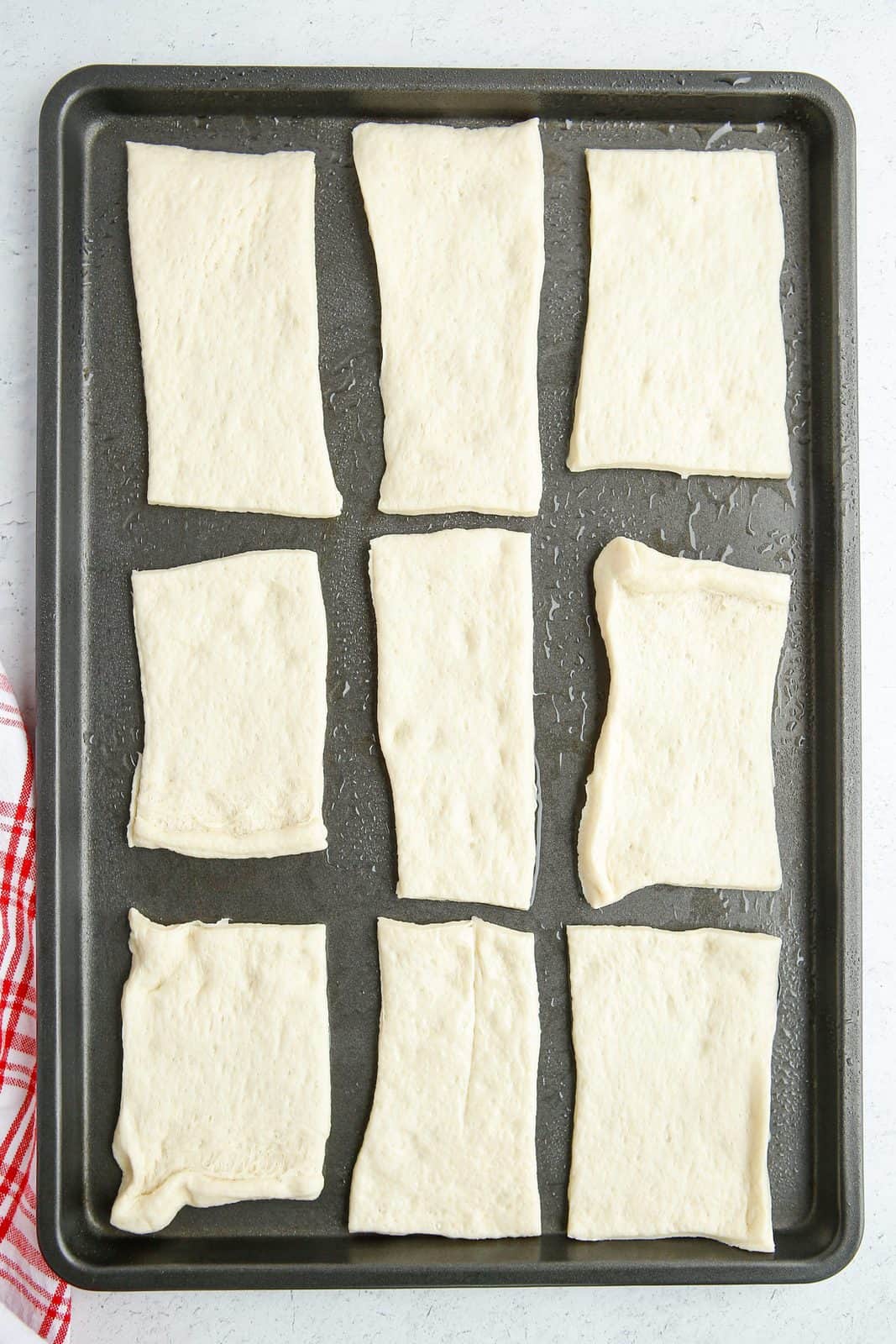 Cut up rectangles of pizza dough on prepared baking sheet.