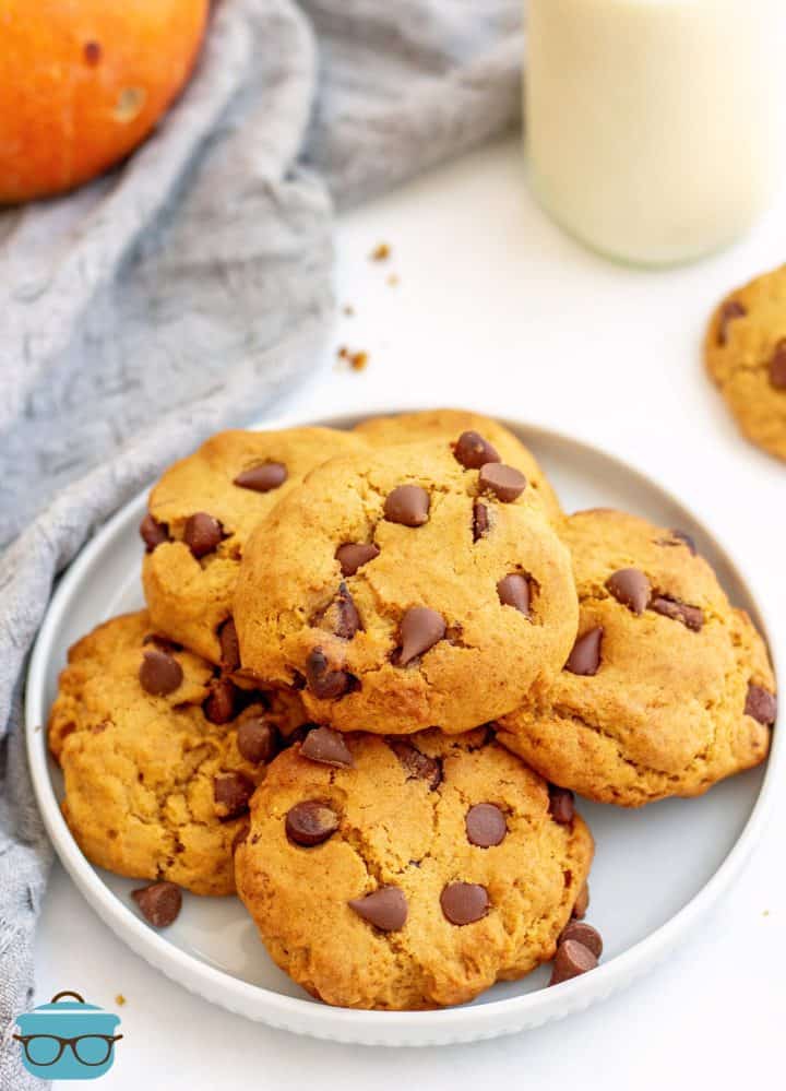 Pumpkin Chocolate Chip Cookies stacked on white plate.