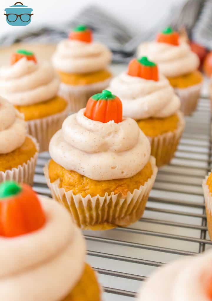Homemade Pumpkin Cupcakes frosted and decorated lined on wire rack.