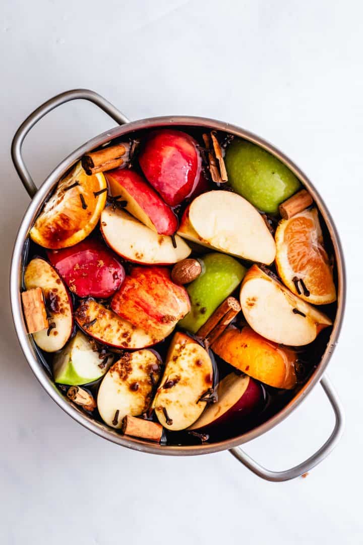 Apples, orange, cinnamon, cloves, nutmeg and brown sugar added to a large pot.