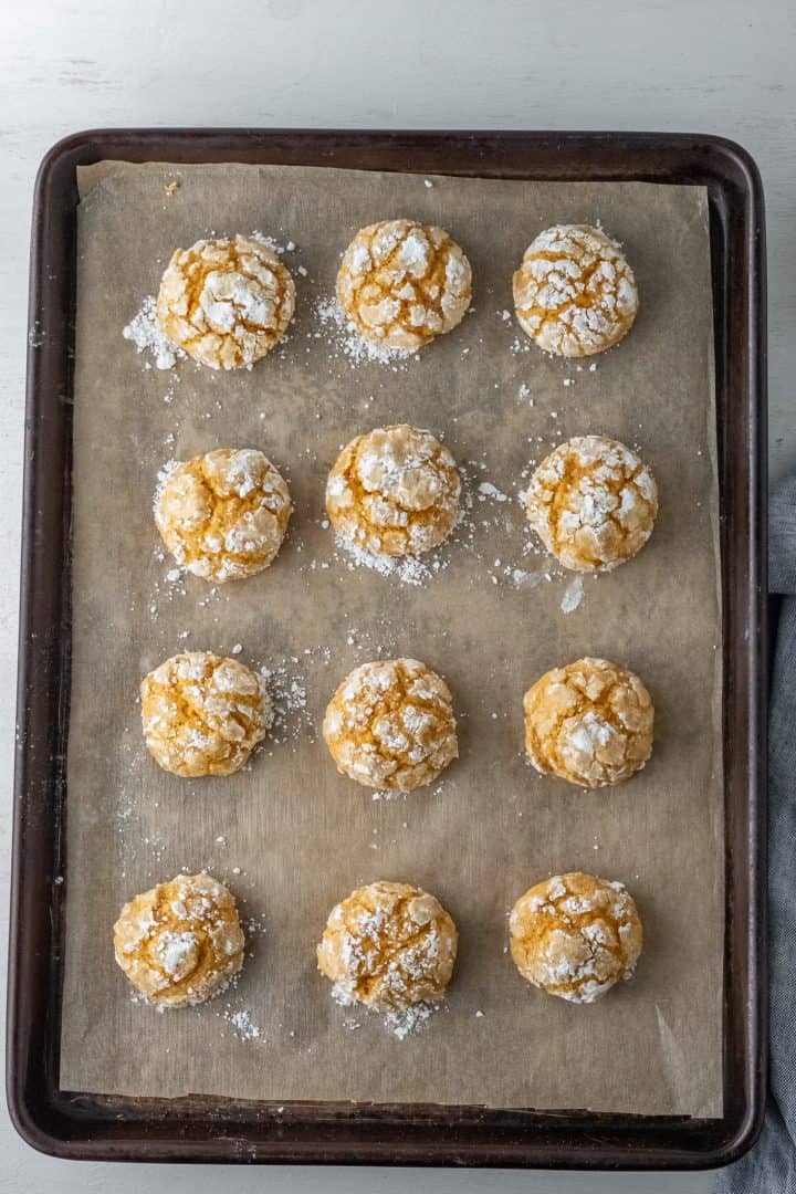 Finished baked Pumpkin Crinkle Cookies on natural parchment paper-lined baking sheet.