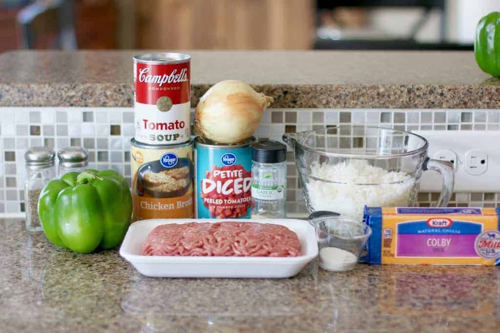 ingredients for stuffed pepper soup: ground beef, onion, green pepper, diced tomatoes, tomato soup, chicken broth, cooked rice, sugar. garlic powder, salt, pepper, shredded cheddar cheese.