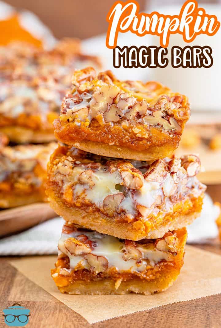 Pinterest image of three stacked Pumpkin Magic Bars on parchment paper.