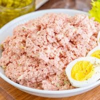 Square image of Old-Fashioned Bologna Salad in bowl with split hard boiled egg.