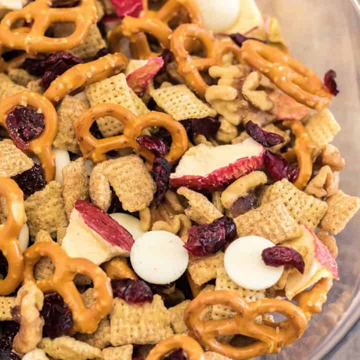 Square image close up of trail mix in clear bowl showing all ingredients.