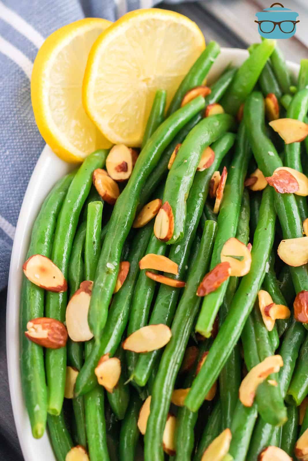 Close up over head of Almond Green Beans with lemon slices.