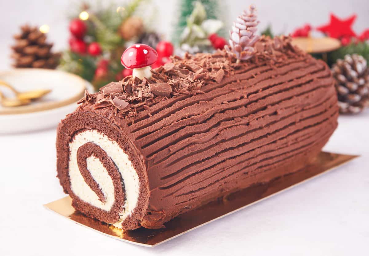 Side view of Christmas Yule Log Cake decorated showing inside swirl.