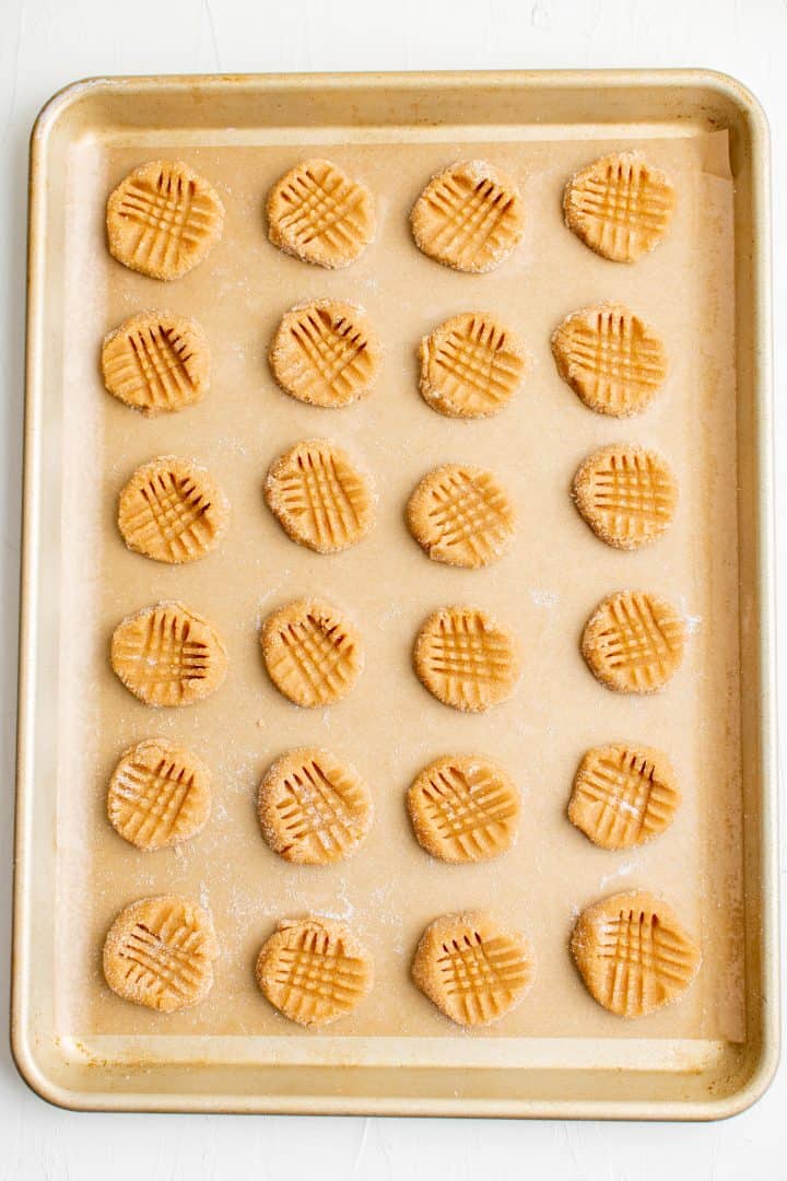 Cookies on baking sheet pressed in a crosshatch pattern with fork.