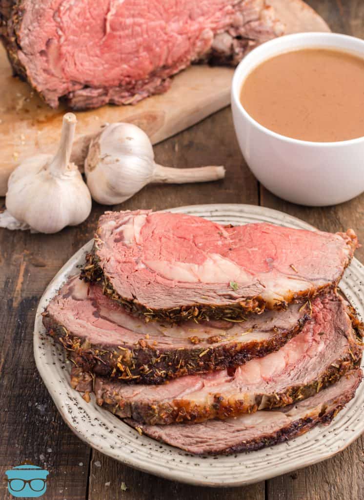 Sllice of Garlic Butter Prime Rib on plate with au jus in background.