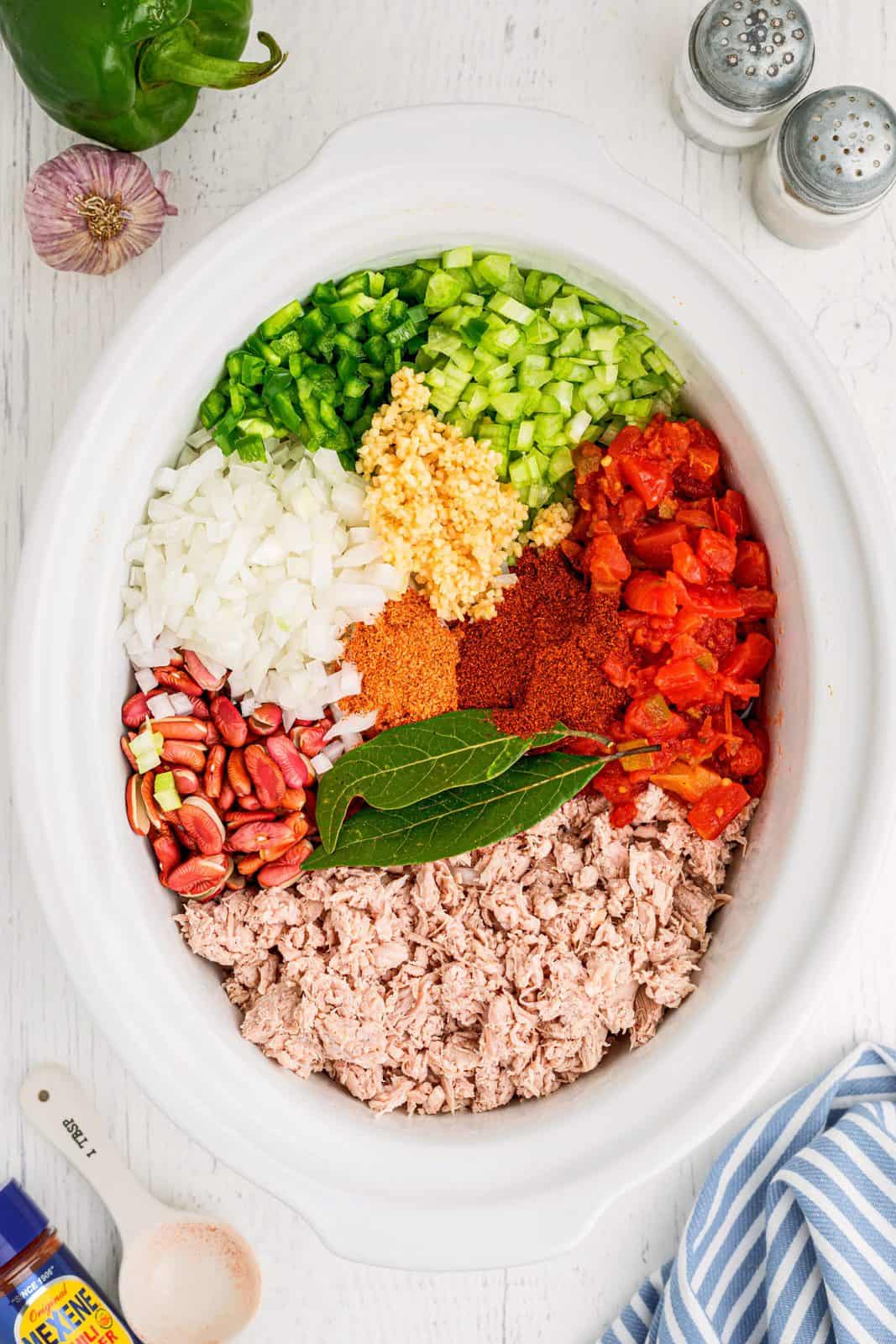 All ingredients added to an oval white crock pot.