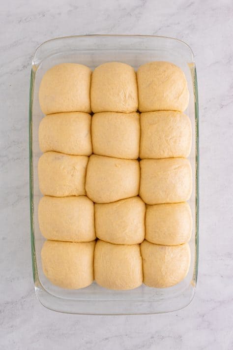 Risen dough balls in pan.