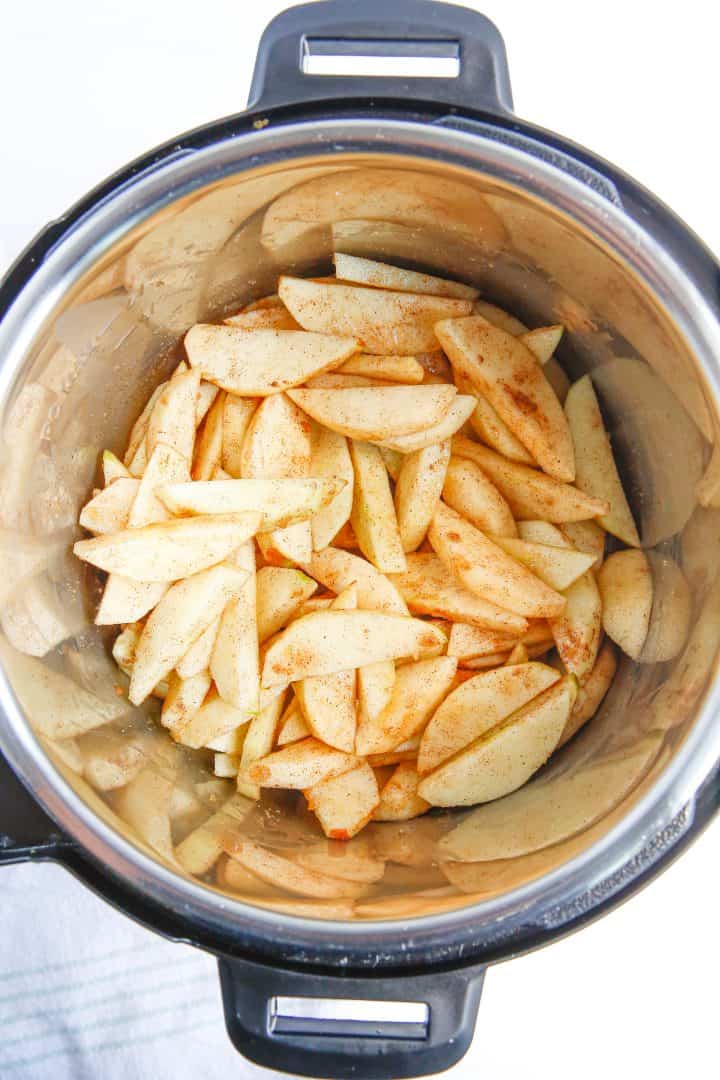 Apples stirred together with ingredients in instant pot.