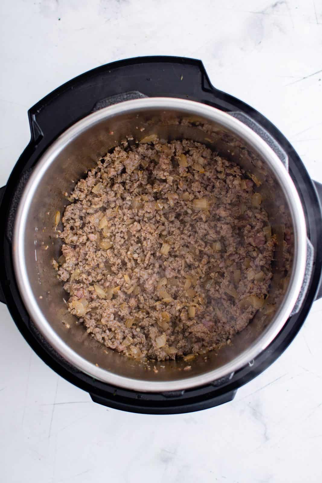 Ground italian sausage added to instant pot and cooked.