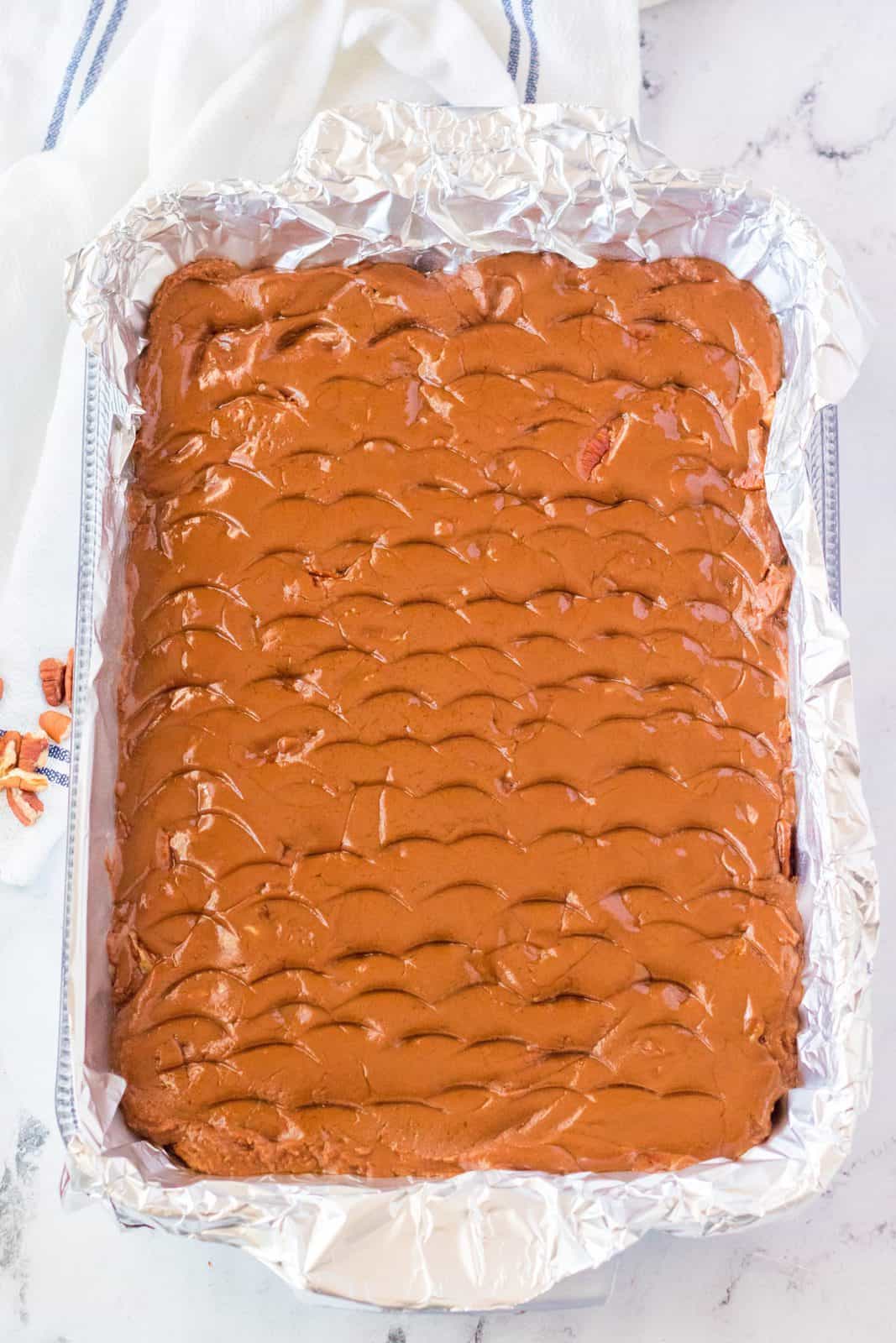 Fudge pressed into a lined baking pan.