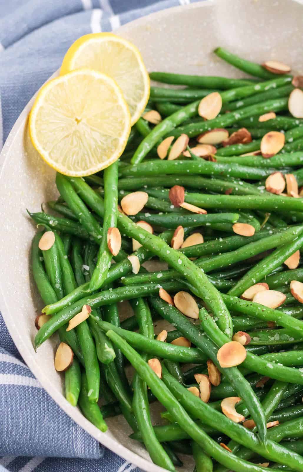 Bowl of Almond Green Beans with lemon slices.