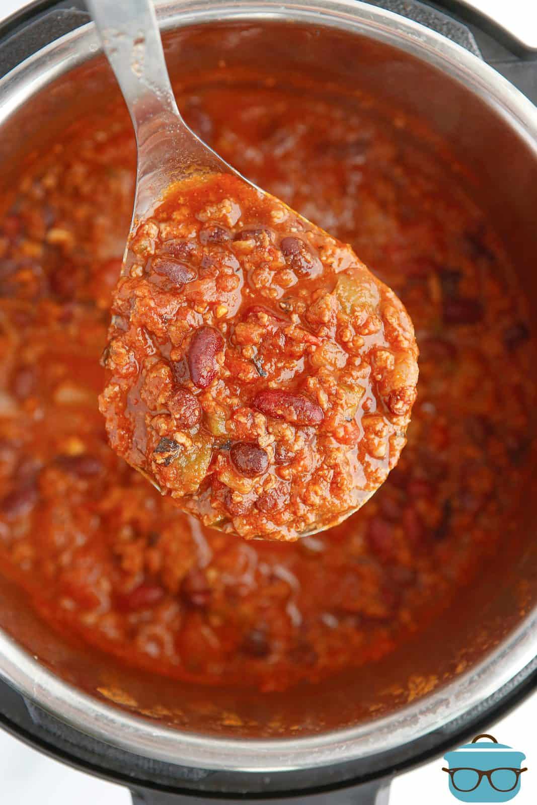 Spoon with Instant Pot Chili Recipe on it over instant pot.