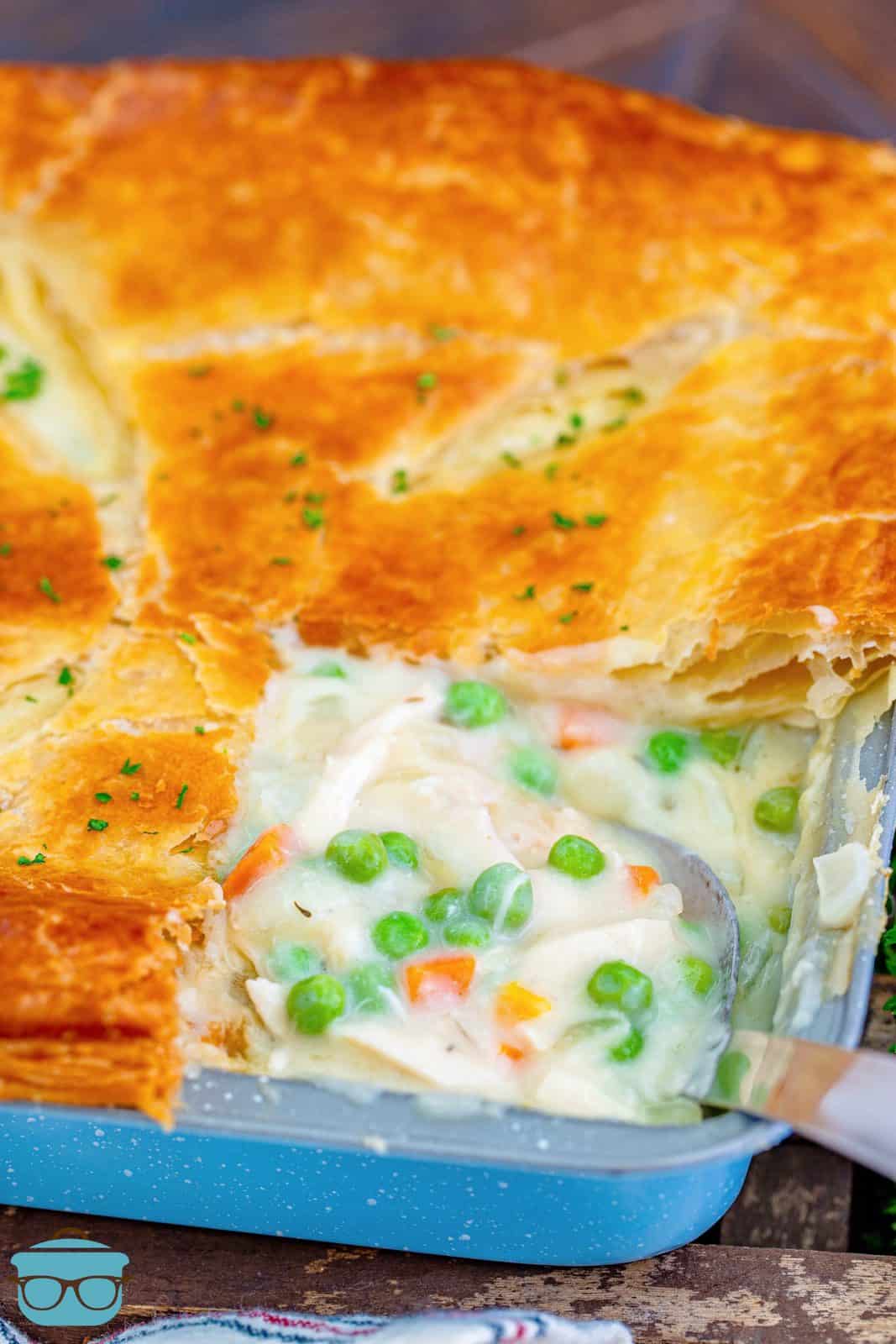 Cut Puff Pastry Chicken Pot Pie in pan with serving spoon.