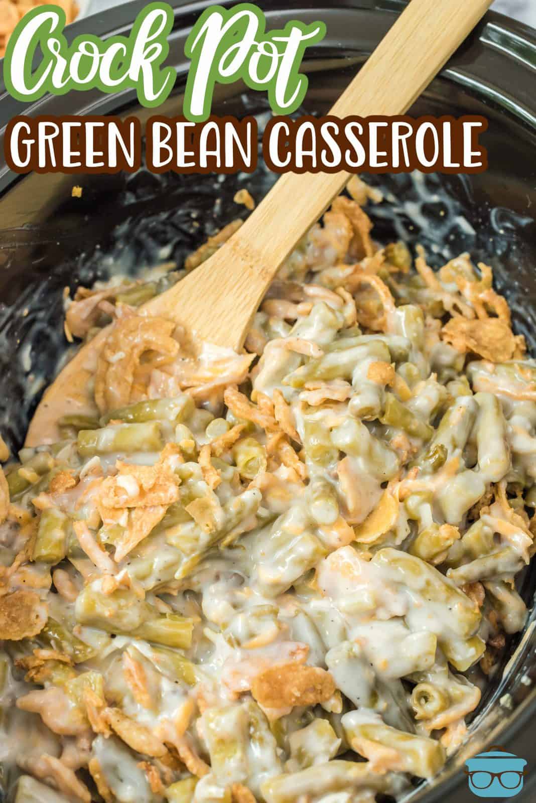 Pinterest image of finished Crock Pot Green Bean Casserole Recipe with spoon in casserole.
