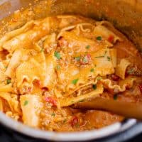 Square image close up with wooden spoon in Instant Pot Lasagna Soup.