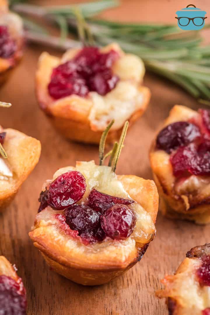 Closeup photo of a cranberry brie appetizer on a wooden surface. 