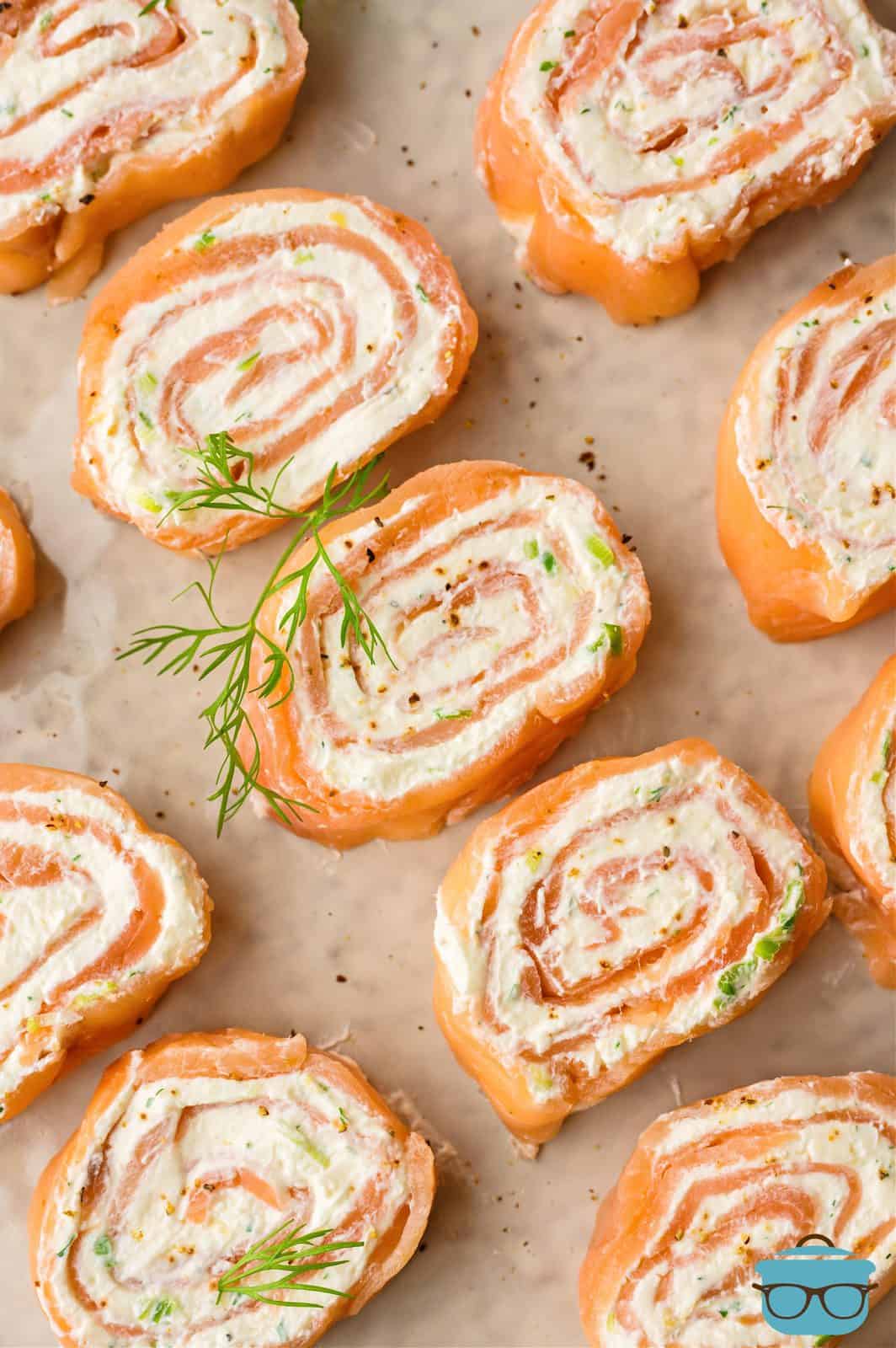 Overhead of slice Salmon Pinwheels on brown parchment paper.