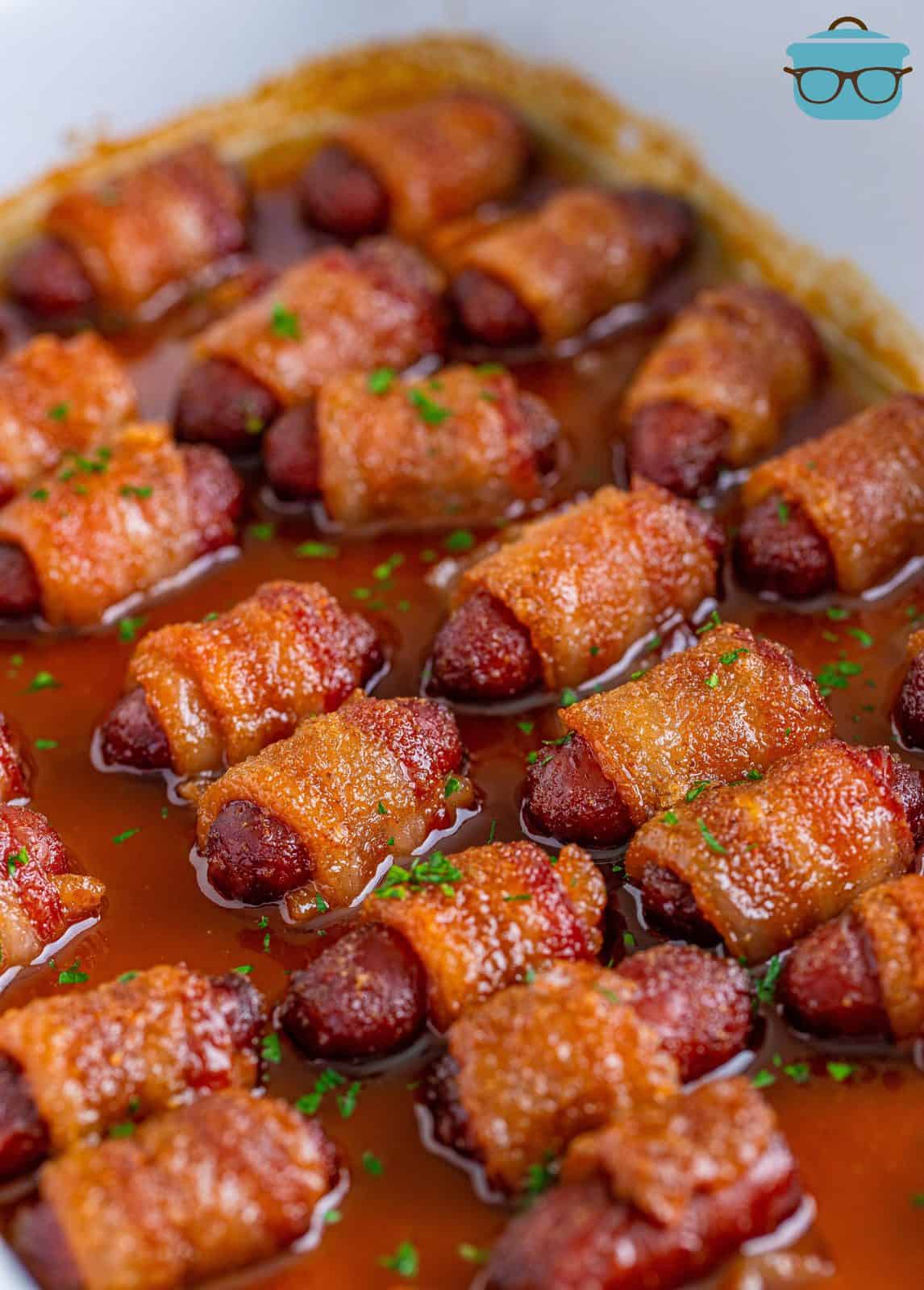 Brown Sugar Bacon Wrapped Little Smokies in baking dish with juices.