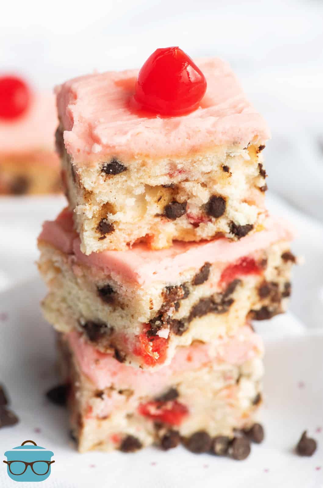 Three stacked Cherry Chocolate Chip Bars topped with a cherry.