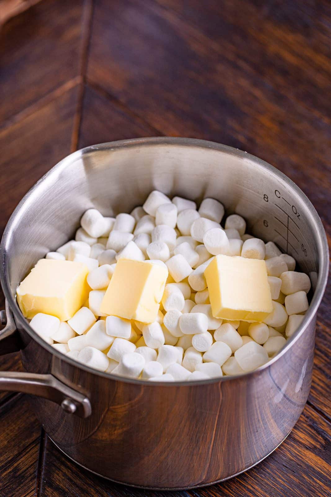 mini marshmallows and pats of butter shown in a saucepan.