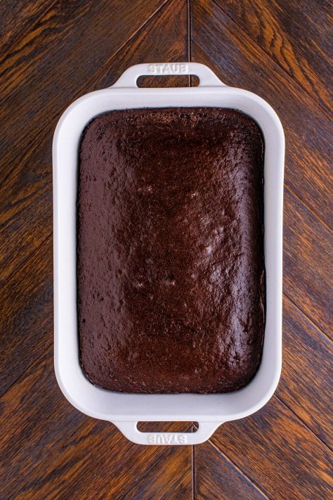 fully baked dark chocolate cake in a white baking dish.