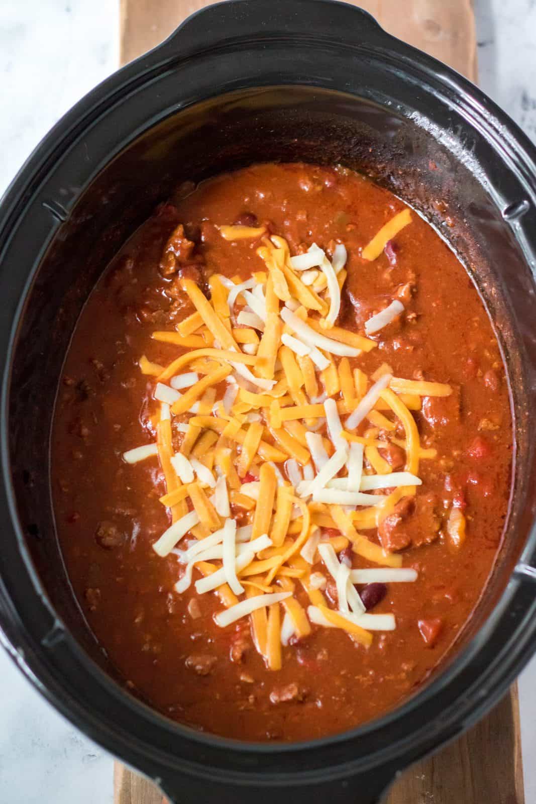 Finished chili topped with cheese in slow cooker.