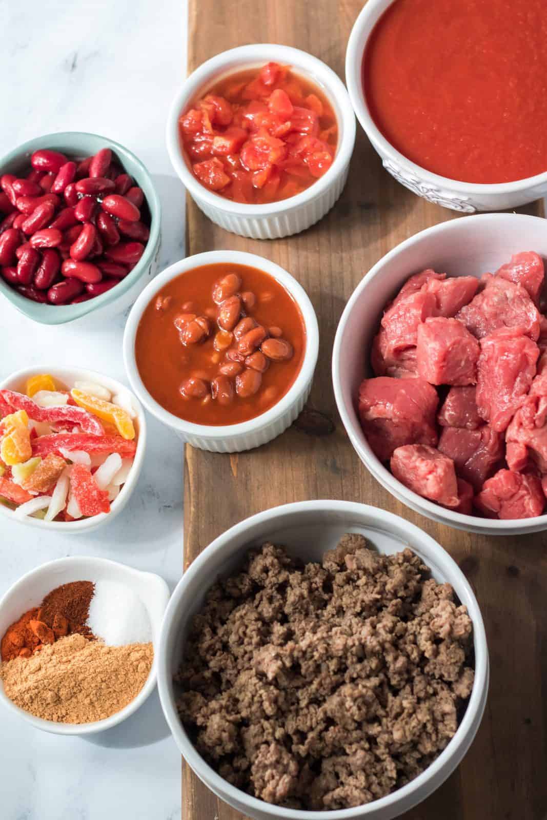 Ingredients needed: stew beef, ground beef, tomatoes with green chiles, tomato sauce, dark red kidney beans, chili beans, frozen mixed peppers and onions, taco seasoning, chili powder, paprika and granulated sugar.