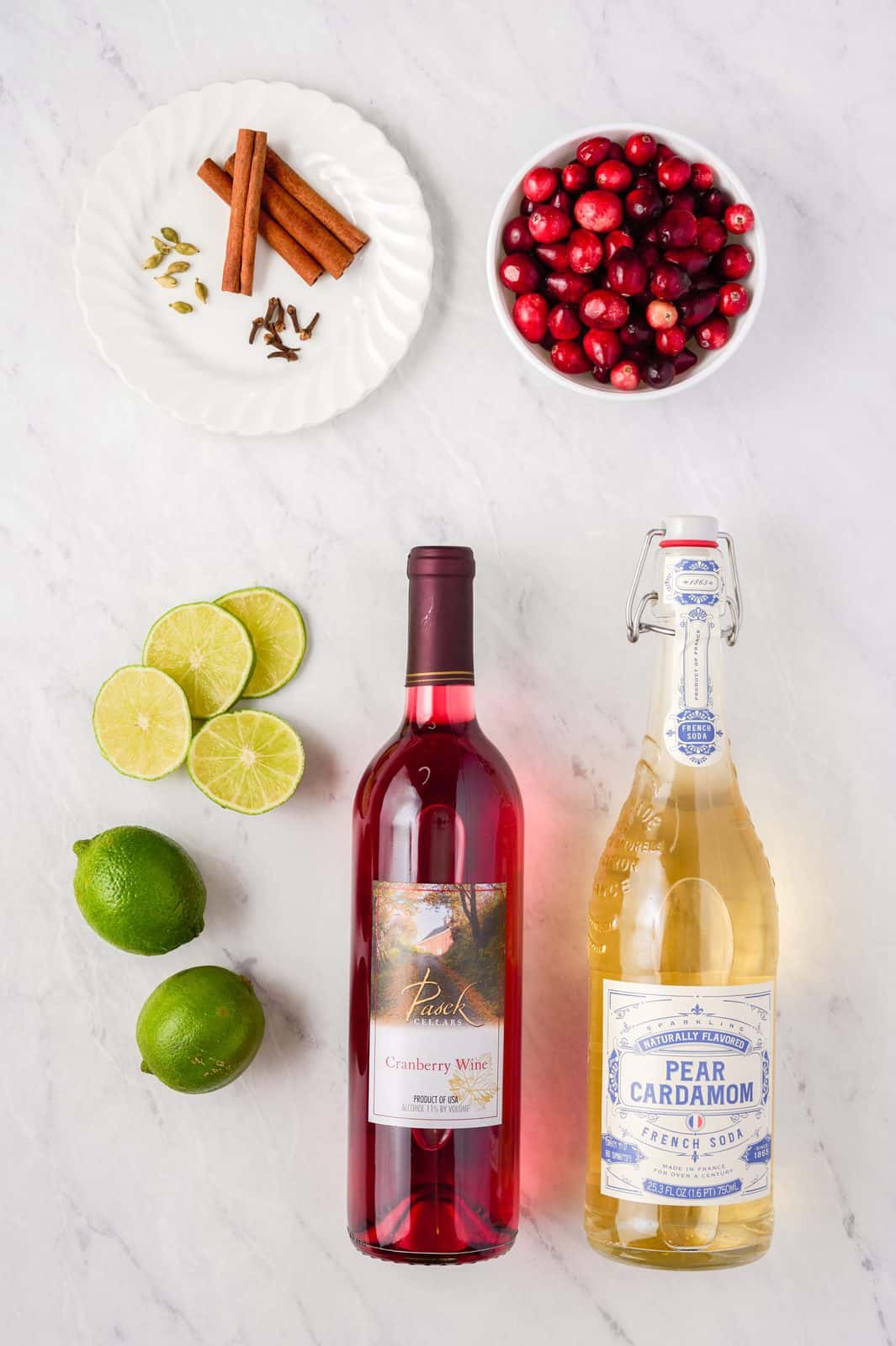 Ingredients needed: cranberry wine, pear cardamom soda, cloves, cinnamon sticks, limes, cranberries and cardamom pods.