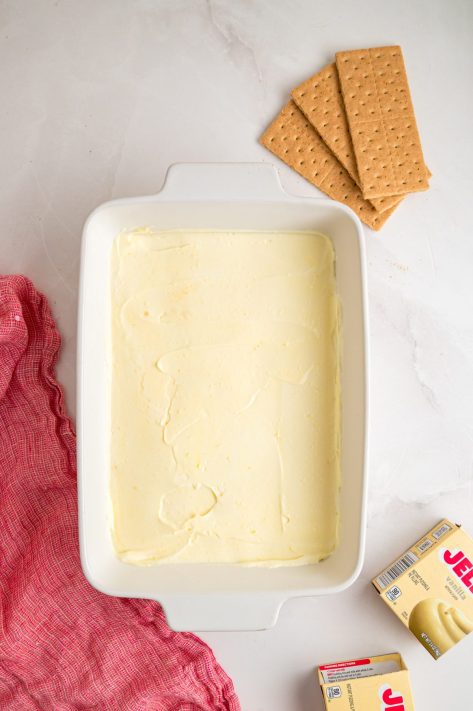 Pudding mixture over graham crackers in a dish.