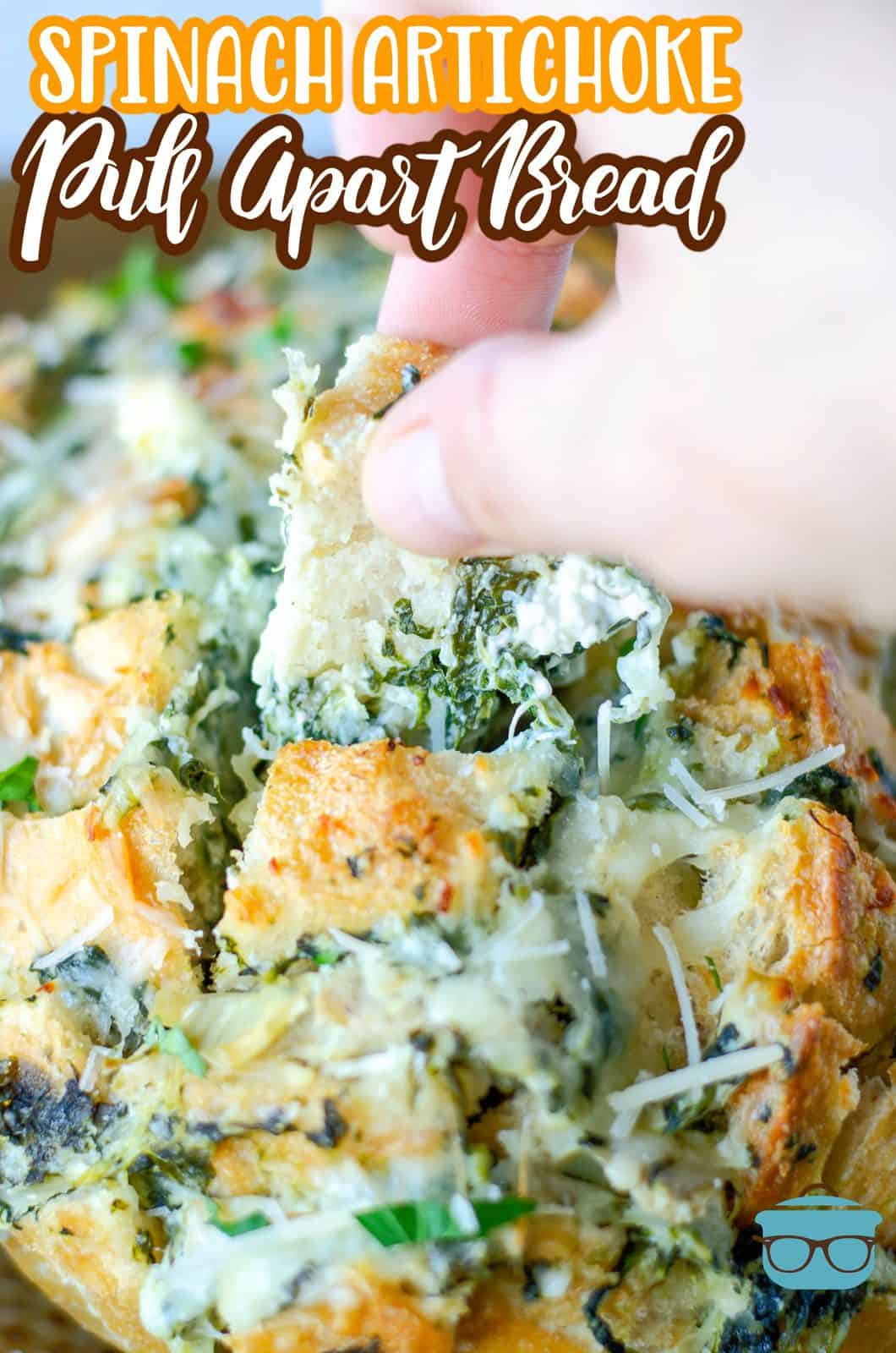 Pinterest image of hand pulling apart some of the Spinach Artichoke Pull-Apart Bread.