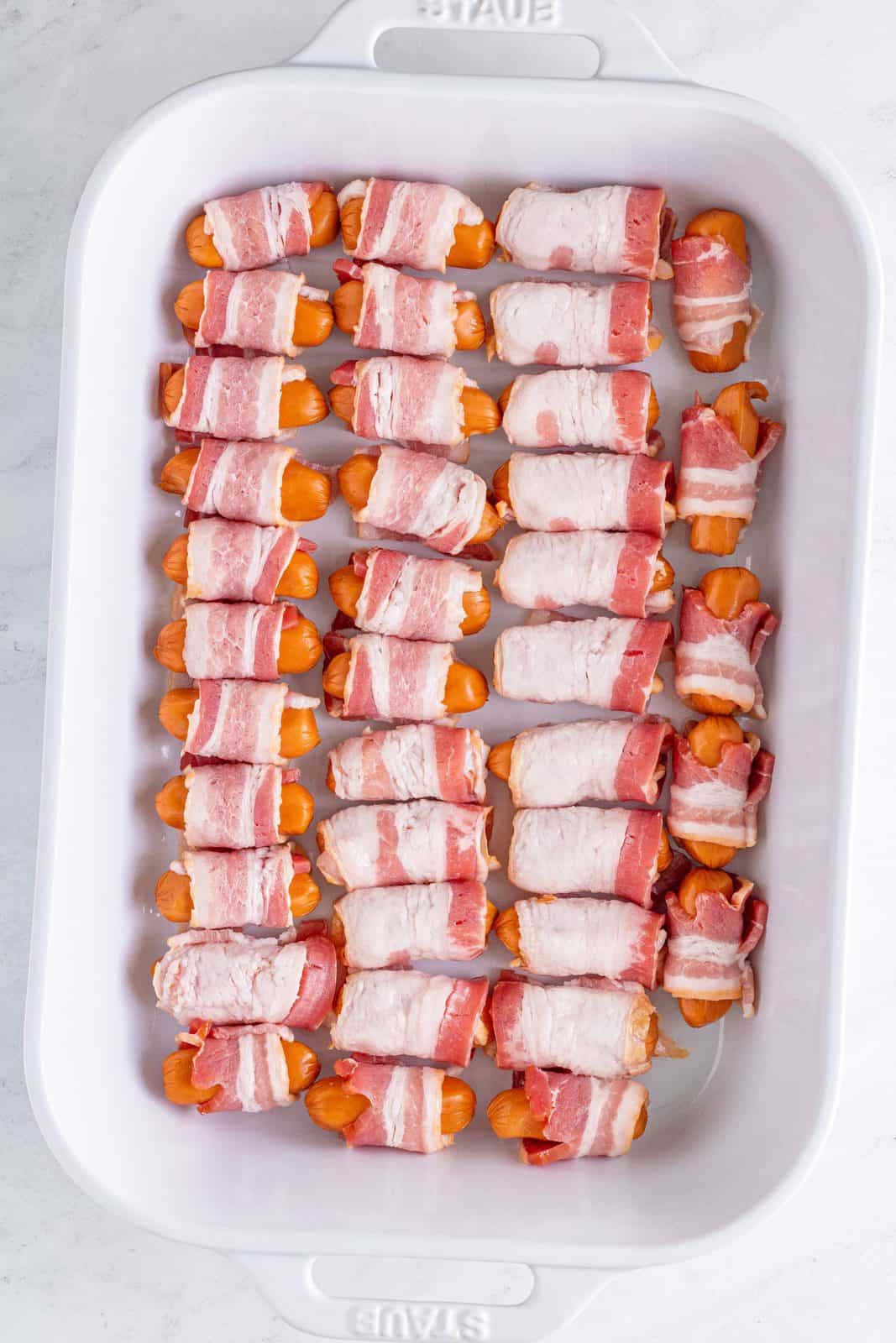 Little Smokies wrapped in bacon in baking dish.