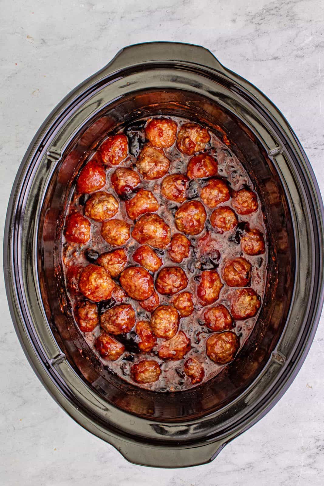 Grape jelly and chili sauce added to crock pot and mixed together with meatballs.